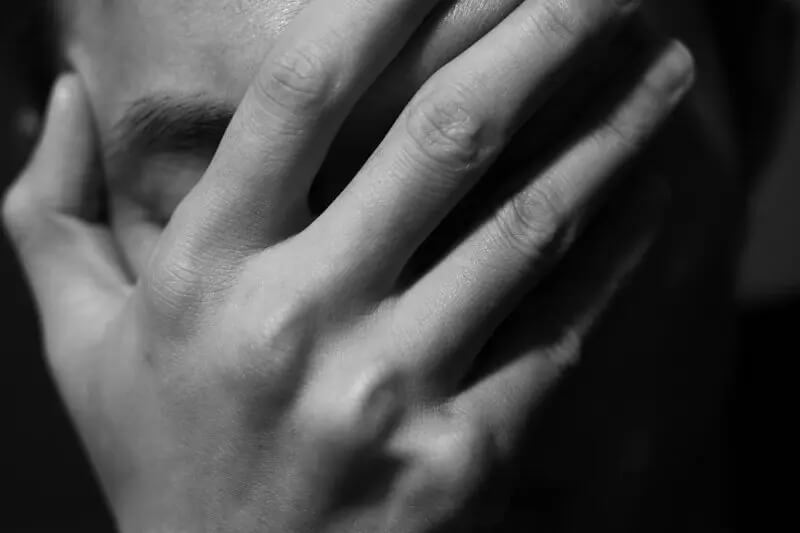 Hand on face showing extreme grief